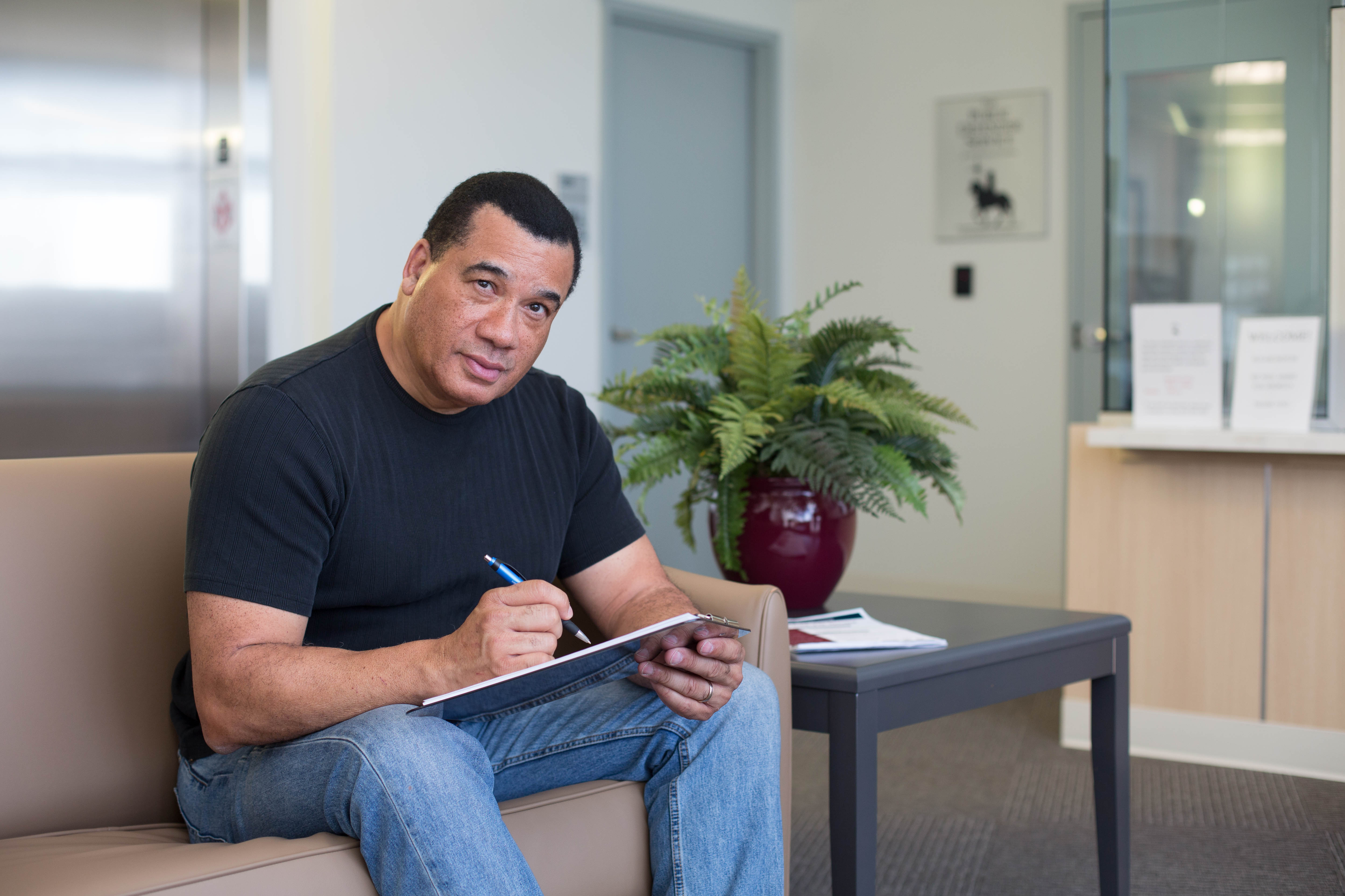 Man filling out a form in PDS reception area.