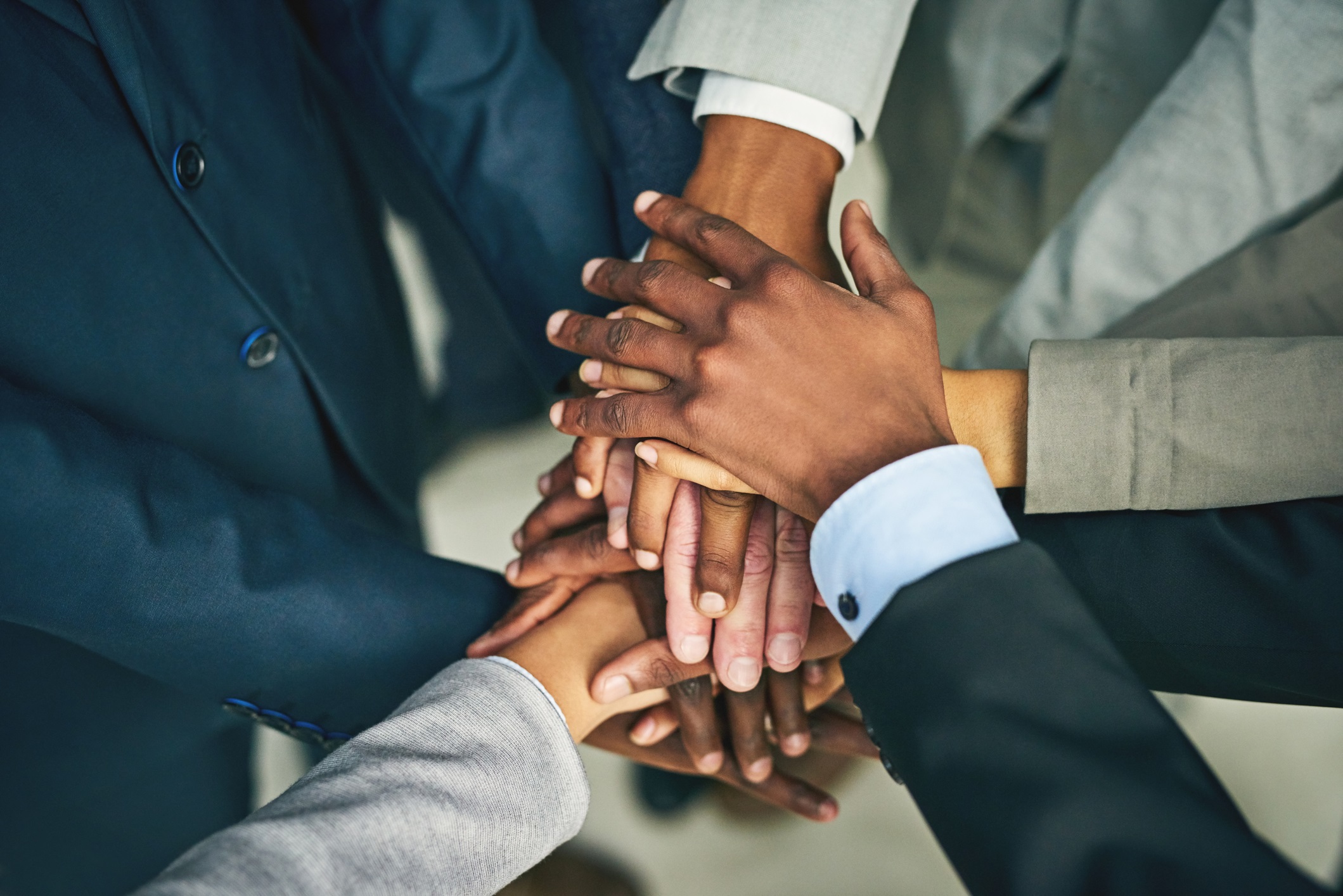 Hands over hands in a collaborative and supportive fashion.